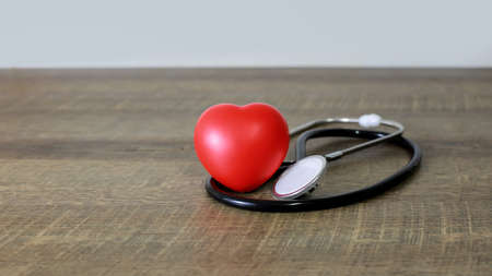 Stethoscope and heart examination red on old wooden floor health care conceptの写真素材