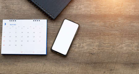 Smartphone,calender on old woodle background top view mockup screen.