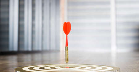 The dart board has an arrow thrown into the center of the shooting target for business targeting.