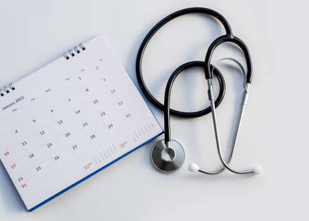 Headphones with date on the calendar page on a gray background Health care concept.の写真素材