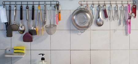 Hanging kitchen utensils are organized for use.の写真素材