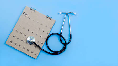 Calendar, stethoscope, on a blue background, health care concept.の写真素材