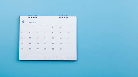 White calendar laying on blue background planning concept.の写真素材