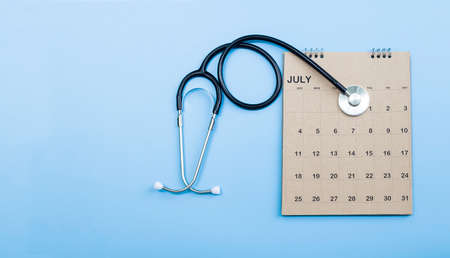Calendar, stethoscope, on a blue background, health care concept.の写真素材