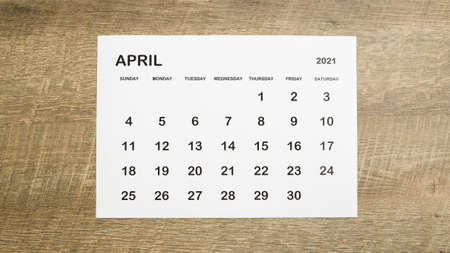 April calendar on a brown wooden table, concept planner.