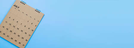 Brown desk calendar on a blue background.の写真素材