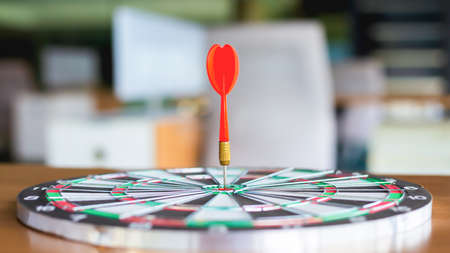 The dart board has an arrow thrown into the center of the shooting target for business targeting.の写真素材
