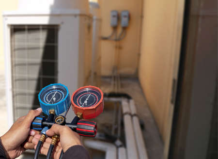Technician checking the operation of the air conditioner.の写真素材