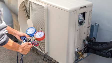 Technician checking air conditioning operation, detecting refrigerant leaks.の写真素材
