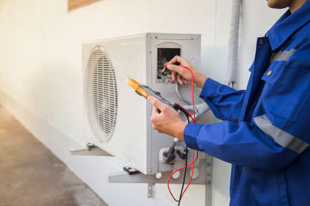 Technician checking the operation of the air conditionerの写真素材