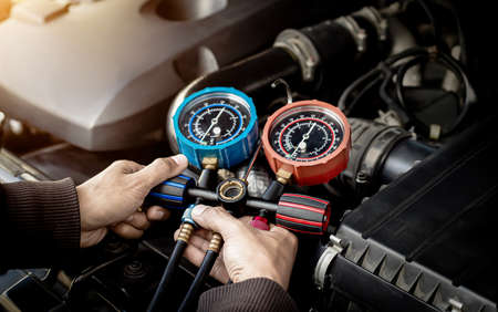 Car air conditioner check service, leak detection, fill refrigerant.Device and meter liquid cooling in the car by specialist technicians.の写真素材