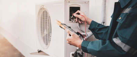 Technician checking the operation of the air conditionerの写真素材