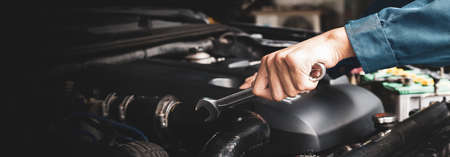 Car mechanic working on car engine, car maintenance concept.の写真素材