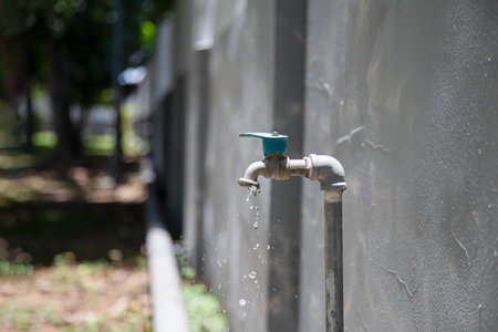 Old faucet outside the house drippingの写真素材