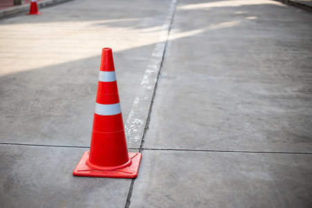 Orange traffic cones on cement road surface.の写真素材