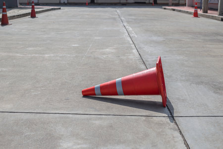 Orange traffic cones on cement road surface.の写真素材