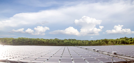 Solar Panels in the field with blue sky and white clouds.