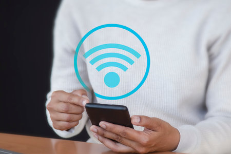 Woman using mobile phone with wifi icon on screen. Technology and communication concept.の写真素材