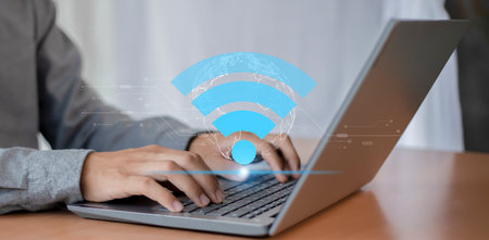 Businessman using laptop computer with wifi icon. Internet and technology concept.
