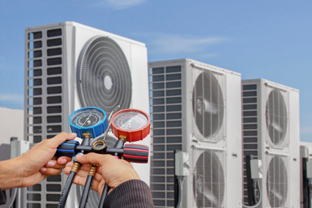 Air conditioning, HVAC service technician using gauges to check refrigerant and add refrigerant.の写真素材