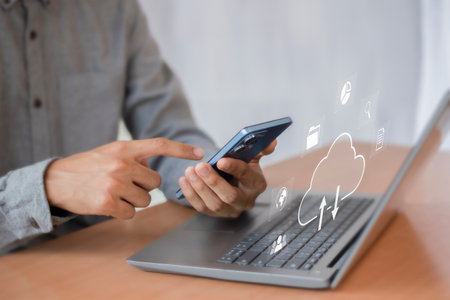 Man using smartphone with cloud computing symbol on screen. Cloud computing concept.