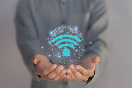 Hand holding Wi-Fi internet, wireless network with icons on young man's hand