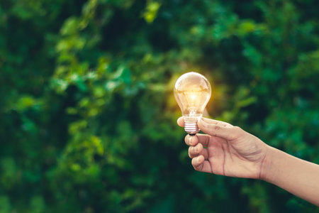 Hand holding light bulb,natural energy and love the world concept.