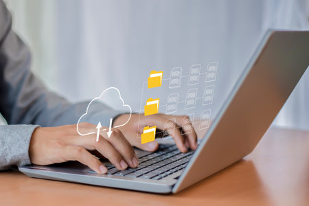 Businessman working on laptop computer with cloud storage icon on screen.の写真素材