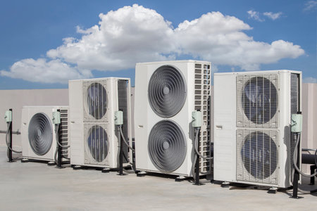 Air conditioning HVAC on the roof of an industrial building with blue sky and clouds