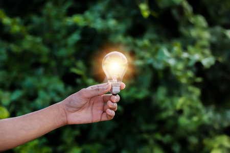 Hand holding light bulb on nature background, Business idea and innovation conceptの写真素材