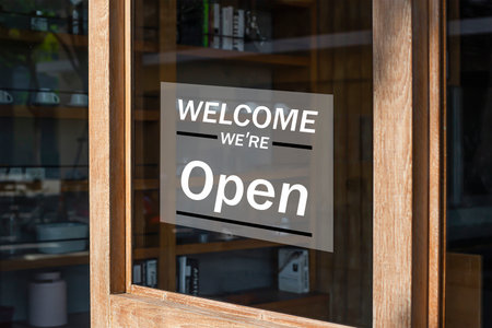 WELCOME TO OPEN sign on the glass door of a shop