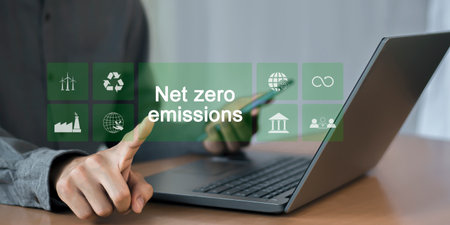Businessman using a laptop with net-zero emissions concept on the screenの写真素材