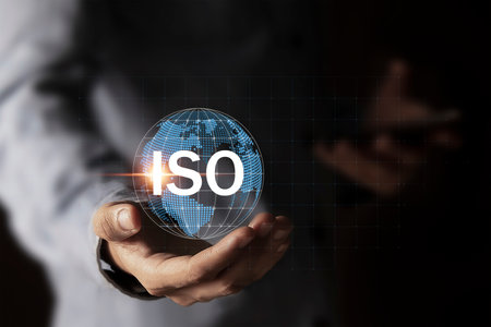 Quality control, certification and assurance concept according to ISO standards. Businessman using mobile phone with document and quality certification icons for ISO.の写真素材