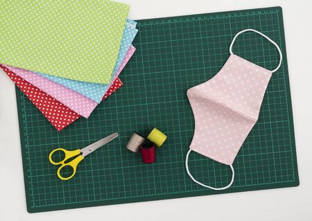 Top view of DIY fabric cotton face mask on green cutting mat. Protect saliva, cough, dust, pollution...