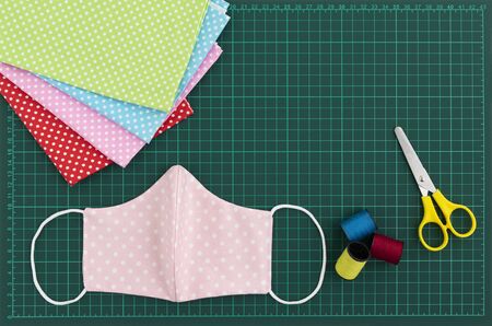 Top view of DIY fabric cotton face mask on green cutting mat. Protect saliva, cough, dust, pollution (PM2.5), Virus, Bacteria, COVID-19. Handmade concept.の写真素材
