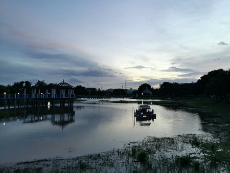 Sun down at the lake beside the park.
