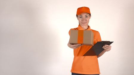 Courier in orange uniform giving a parcelの写真素材