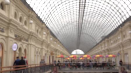 Blurred people walking in shopping mall with glass roof. Background shotの写真素材