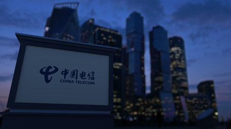 Street signage board with China Telecom logo in the evening. Blurred business district skyscrapers background. Editorial 3D United Statesのeditorial素材