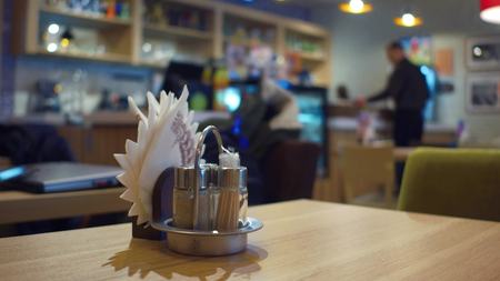 Cafe table foreground and blurred waiter at work