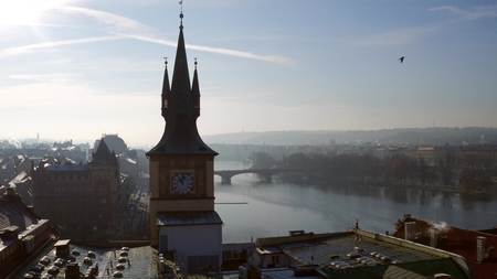 Clock tower against Vltava river in Prague on a sunny day, Czech Republic
