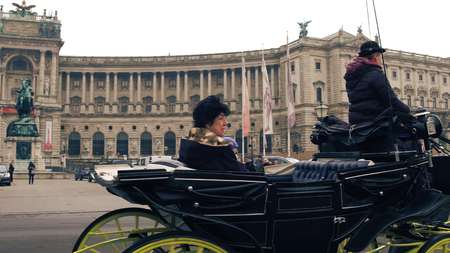 VIENNA, AUSTRIA - DECEMBER, 24 Retro horse-drawn carriage against Austrian National Library on Heldenplatz. Popular touristic attractionのeditorial素材