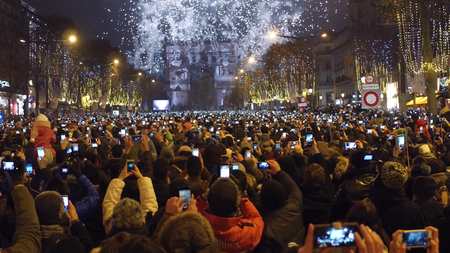 PARIS, FRANCE - DECEMBER, 31. New year countdown and fireworks above famous triumphal arch, Arc de Triomphe. Tourists recording videos with their mobile phonesのeditorial素材