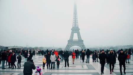 PARIS, FRANCE - DECEMBER, 31. Multinatonal tourists taking photos and making selfie near Eiffel Tower, the most famous French landmarkのeditorial素材