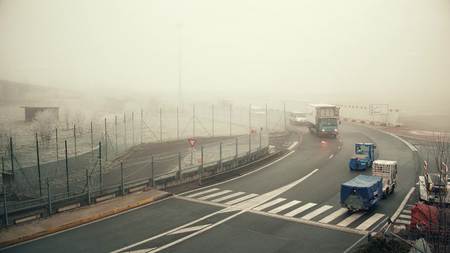 PARIS, FRANCE - JANUARY, 1, 2017. Charles de Gaulle airport utility vehicles on a foggy day. Warm colorsのeditorial素材