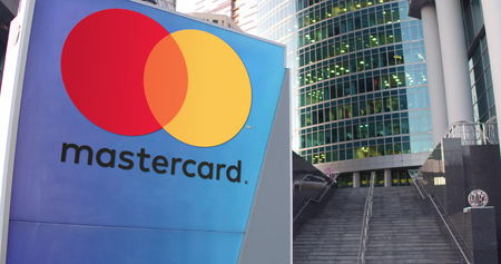 Street signage board with MasterCard logo. Modern office center skyscraper and stairs background. Editorial 3D renderingのeditorial素材