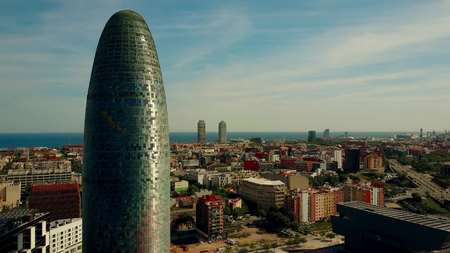 BARCELONA, SPAIN - APRIL, 15, 2017. Torre Agbar skyscraper, city and seafront aerial view on a sunny...