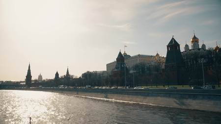 The Moscow Kremlin wall and towers on a sunny day as seen from the river tour boatの写真素材