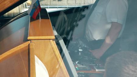 Motor boat skipper at work in wheelhouse