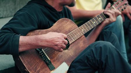 Unidentified mid aged street musician playing the guitar and singing